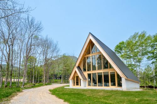 a house with a gambrel roof on a dirt road at ERUSA Rusutsu in Rusutsu