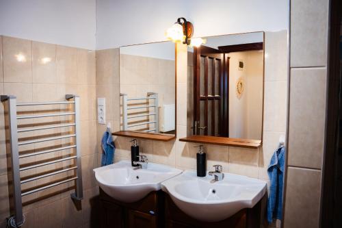 a bathroom with two sinks and a mirror at Kiscsengőd Vendégház in Csengőd