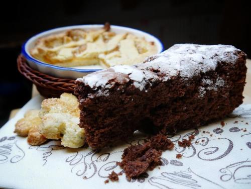 a piece of cake on a plate with a bowl of food at El Sesterzio in Oderzo