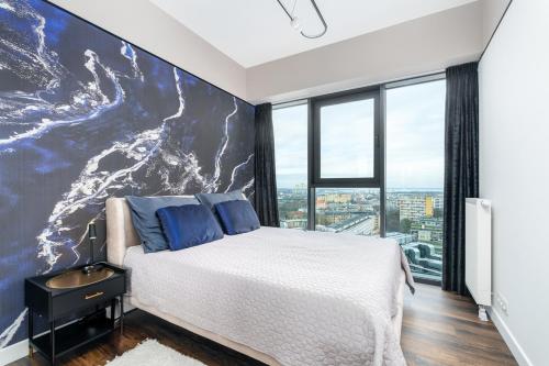 a bedroom with a large painting on the wall at Hanza Signature Sky in Szczecin