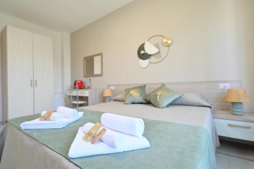 a bedroom with a bed with towels on it at Camere da Angelo in Tortolì
