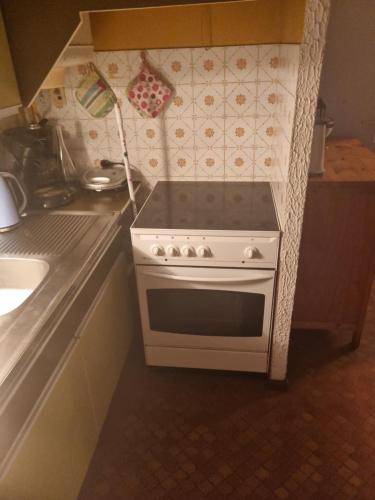 Chez Yvette في بورت لوكات: مطبخ مع موقد وطاولة عمل