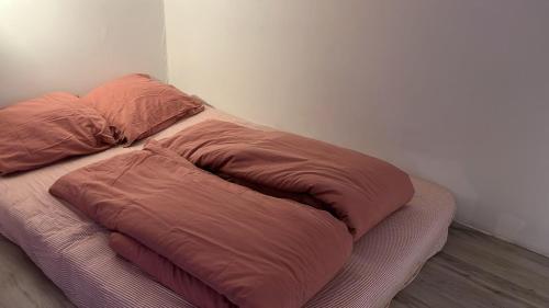 a bed with two pillows on it in a room at La Boulangerette - Studio in Kralingen in Rotterdam
