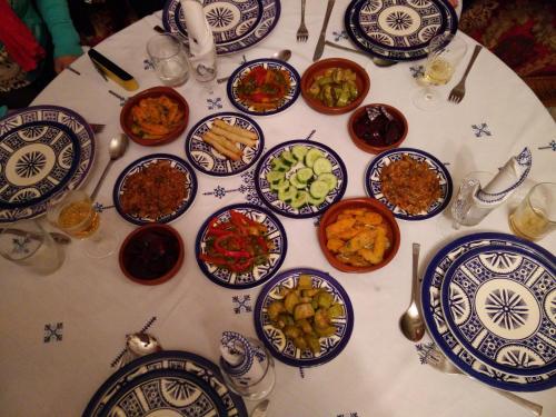 a table with blue and white plates of food on it at Riad Raouia HAMMAM & SPA in Fès