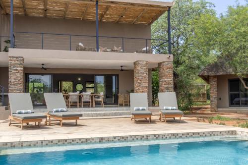 a house with a swimming pool and a patio at Afrikaya Villas in Hoedspruit
