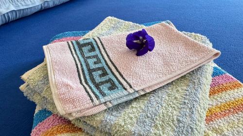a purple flower on top of a pile of towels at Similan Home Stay in Ban Lam Ru (1)