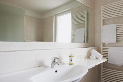 a white bathroom with a sink and a mirror at Garni Kleefeld in Schenna