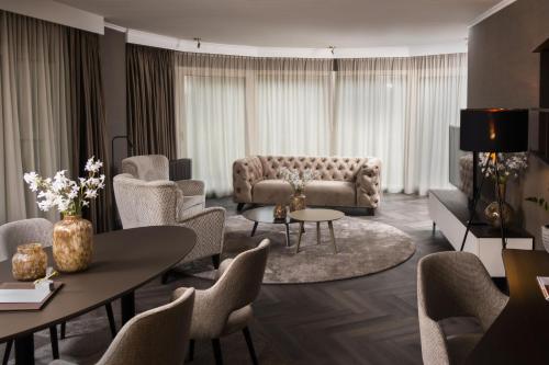 a living room with a couch and tables and chairs at Landgoed Lauswolt in Beetsterzwaag