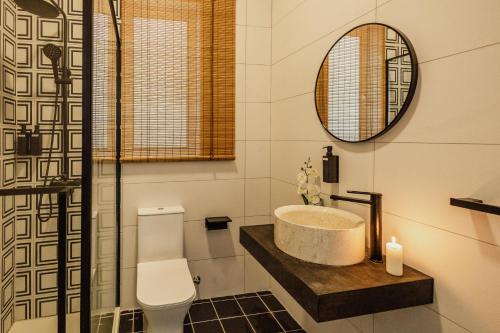 a bathroom with a sink and a toilet and a mirror at St Julians`s Urban Apartments in Is-Swieqi