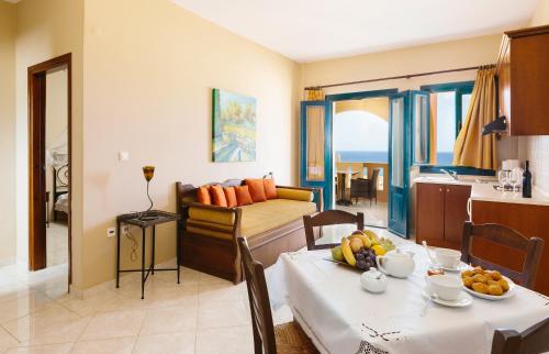 a kitchen and a living room with a table with fruit on it at Archipelagos Apartments in Arkasa