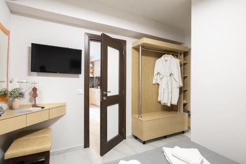 a room with a closet with a robe on a door at Akrogiali Apartments in Bali