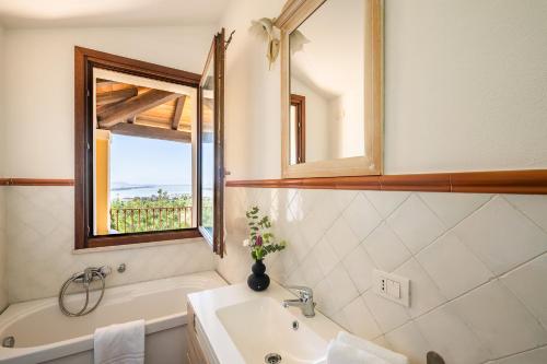 a bathroom with a tub and a sink and a window at Cagliari Bay View Villa in Quartu Sant'Elena