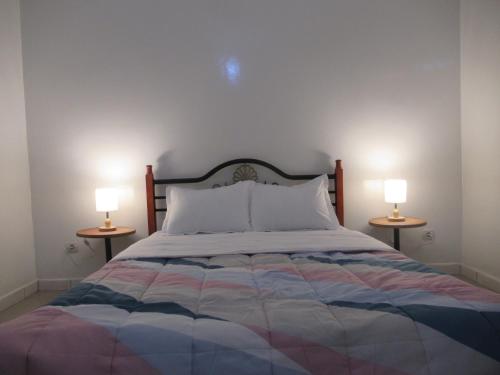 a bedroom with a bed with two lamps on both sides at Résidence Séjour Téranga in Saint-Louis