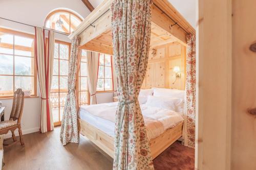 a bedroom with a canopy bed in a room with windows at Gästehaus Eltz - Your Austrian Home in Puchen