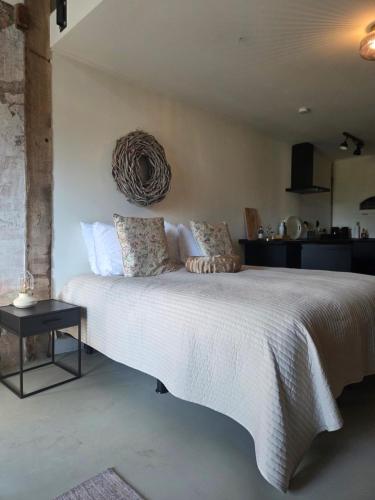 a bedroom with a large white bed and a table at De Citadel - De Boomgaard in Markelo