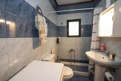 a bathroom with a toilet and a sink at Nikiana Panorama in Nikiana