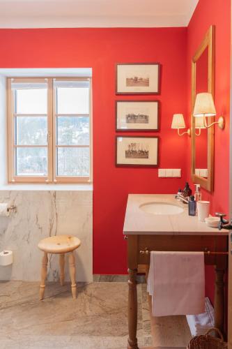 a bathroom with a sink and a red wall at Gästehaus Eltz - Your Austrian Home in Puchen
