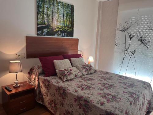 a bedroom with a bed and a painting on the wall at O Xuncal in San Cosme de Barreiros