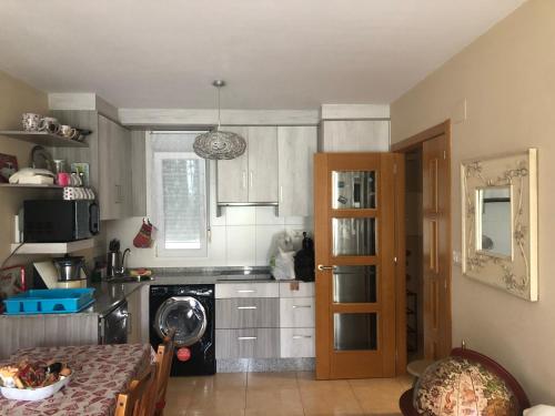 a small kitchen with a table and a microwave at O Xuncal in San Cosme de Barreiros