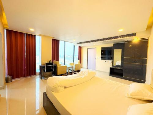 a bedroom with a large bed and a living room at Hotel Ranjana Palace in Pūrnia