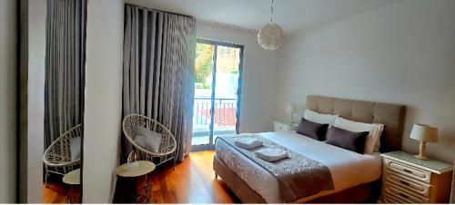 a bedroom with a large bed and a balcony at Ocean Pearl Apartment K in Funchal