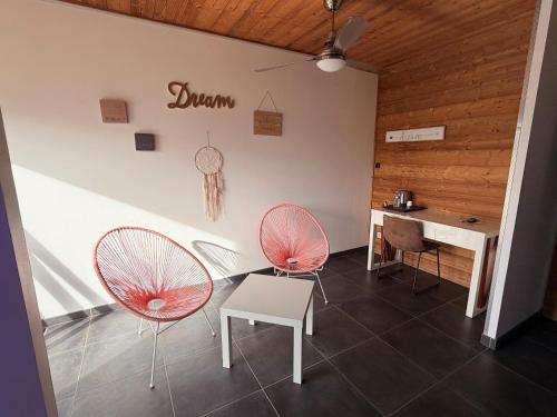 two chairs and a table in a room with a desk at Bio-Motel in Saint-Vulbas