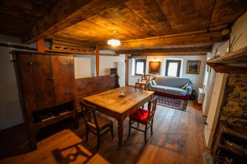a living room with a wooden table and a couch at Walser House in Rimella