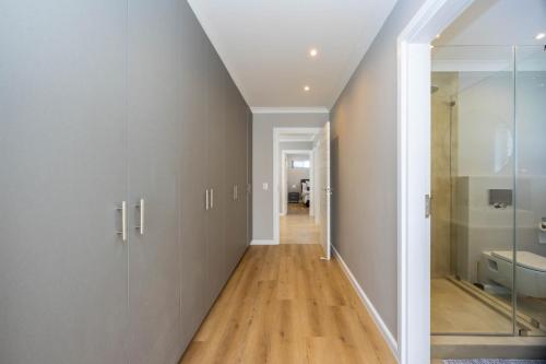 a hallway with white cabinets and a bathroom at Nova Haus in Plettenberg Bay