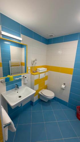 a blue and white bathroom with a sink and a toilet at Pension Duel in Ústí nad Labem