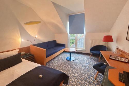 a hotel room with a bed and a couch at Hotel am Kurpark in Schönebeck