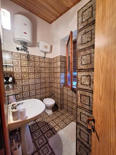 a bathroom with a toilet and a sink at White Cottage - WelcHome in Mozzagrogna