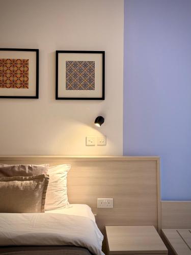 a bedroom with a bed and two pictures on the wall at Apartment 81 in Mosta