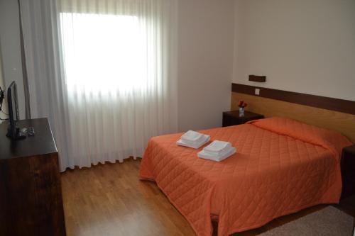 a bedroom with a bed with two towels on it at Encosta do Sossego in Cabeceiras de Basto
