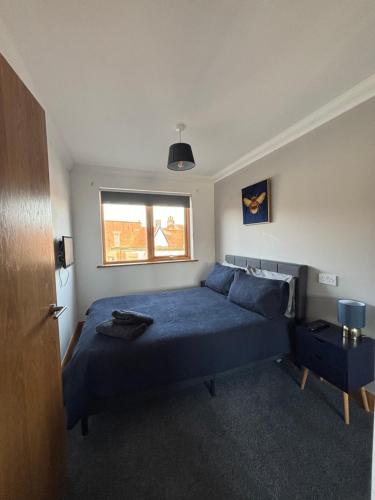 a bedroom with a blue bed and a window at 1 bedroom apartment in Norwich city centre APT 8A in Norwich