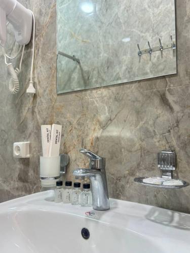 a bathroom sink with a faucet and a mirror at ANNUR Boutique Hotel in Samarkand