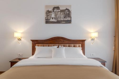 ein Schlafzimmer mit einem großen Bett und zwei Nachttischen in der Unterkunft Casa Doseanu in Oradea
