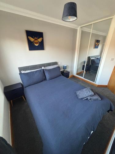 a bedroom with a bed with blue sheets and a mirror at 1 bedroom apartment in Norwich city centre APT 8A in Norwich