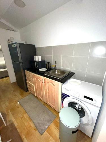 a small kitchen with a washer and a sink at Grand International in Abu Dhabi