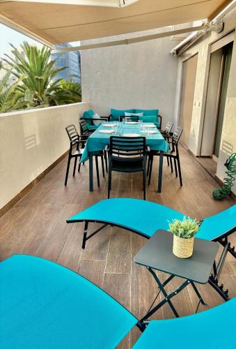 a cafeteria with blue tables and chairs on a balcony at Beachside Holiday Apartment in Mohammedia