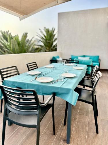 a table with chairs and a blue table cloth at Beachside Holiday Apartment in Mohammedia