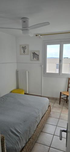 a white bedroom with a bed and a window at Marseille Estaque in Marseille