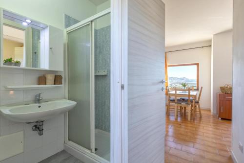 a bathroom with a sink and a shower and a table at L15 Appartamento Asinara in Stintino