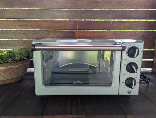 a toaster oven sitting on a wooden deck at Glass House Mountains Retreat Sunshine Coast in Glass House Mountains