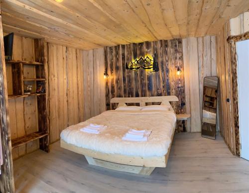 a bedroom with a bed in a room with wooden walls at Будиночок між річками Гирло in Iltsi
