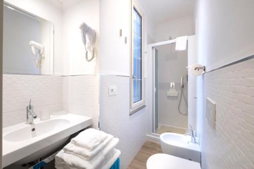 a white bathroom with a sink and a toilet at La Dimora di B.Cairoli in Ovada