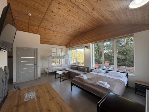 a bedroom with a bed and a couch and windows at Готель Яблуниця in Yablunytsya