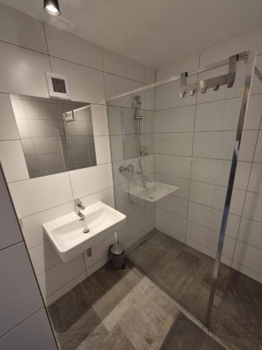 a white bathroom with a sink and a shower at Spiss 21 in Spiss