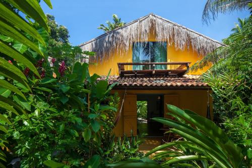 a yellow house with a balcony on top of it at Canoa Nativa Pousada Boipeba in Ilha de Boipeba
