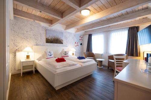 a bedroom with a large white bed in a room at Hotel Anka in Norddorf