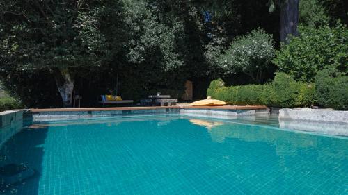 a swimming pool with blue water in a yard at Quinta de São Francisco Houses in Viseu